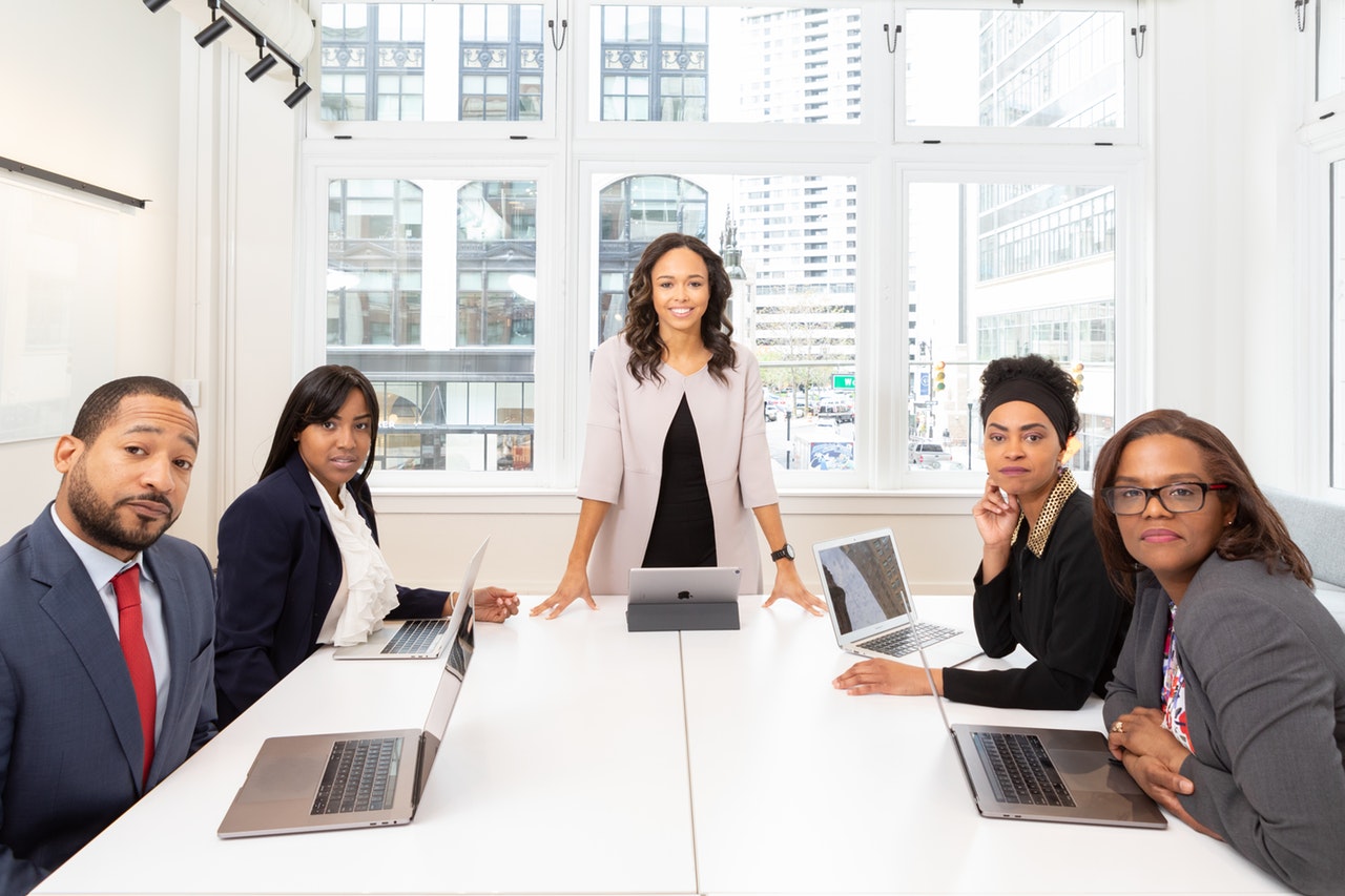 woman-standing-on-the-center-table-with-four-people-on-the-1367271-For Empowering Women To become global leaders Tech companies need to push forward
