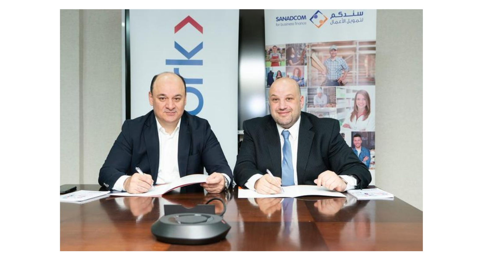 Fadi Amireh, CEO of Sanadcom for Business Finance, and Amjad Al-Sadeq, CEO of Network International Jordan signing the agreement