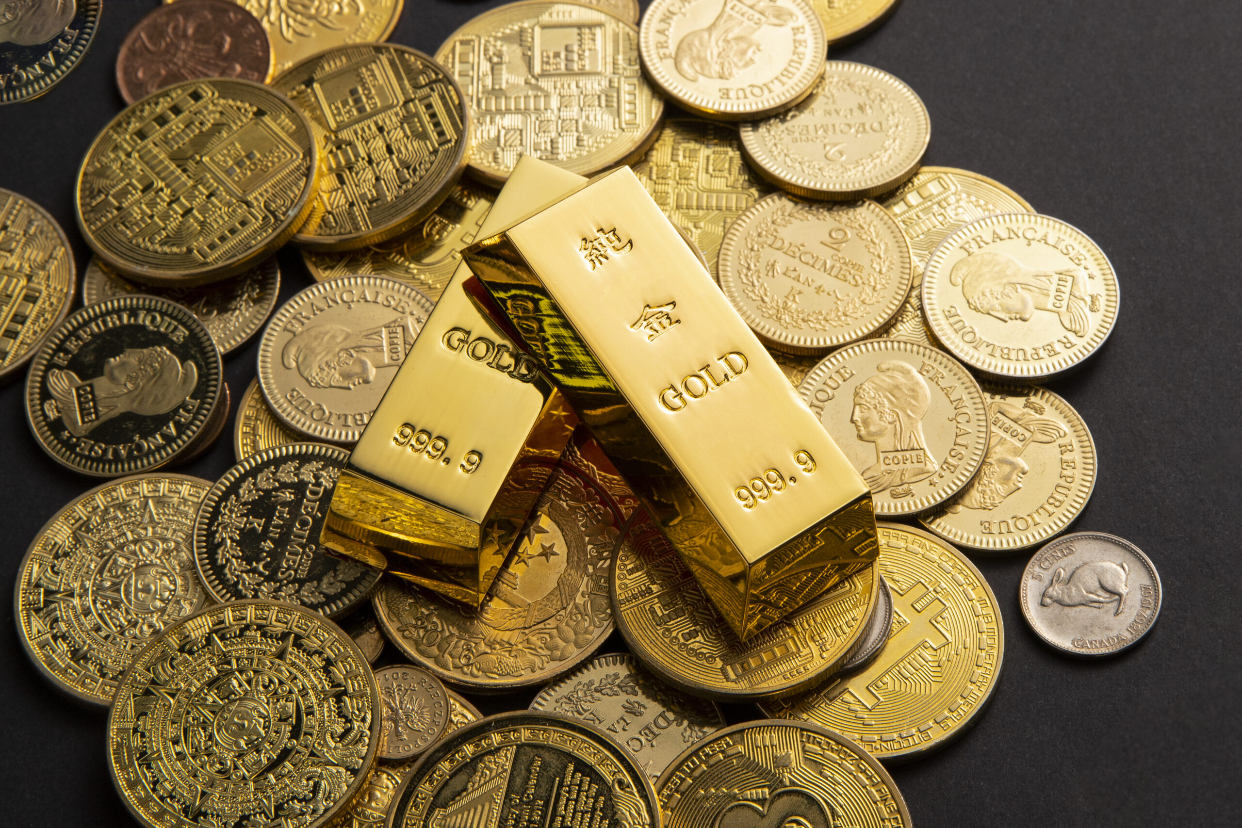 Gold Coins and bars scattered on Table. Image Courtesy: Freepik