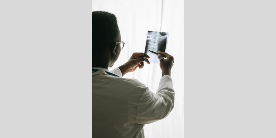 Doctor analyzing an x-ray with a pen. Image Courtesy- Ivan S from Pexels